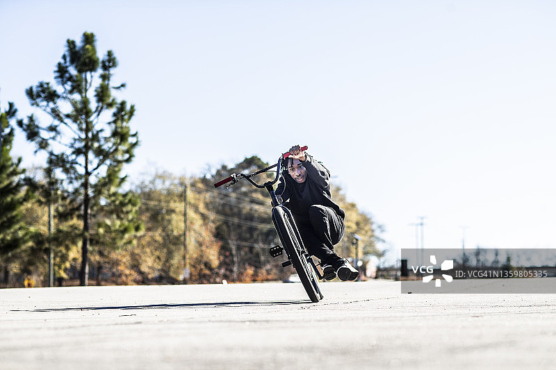 年轻男子BMX骑手在城市区域表演自行车特技图片素材