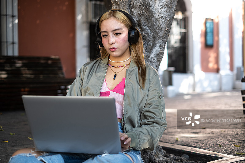 在户外使用笔记本电脑的少女图片素材