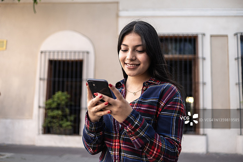 在户外使用手机的少女图片素材