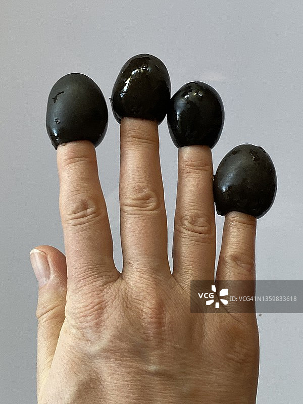 指尖上的黑橄榄图片素材