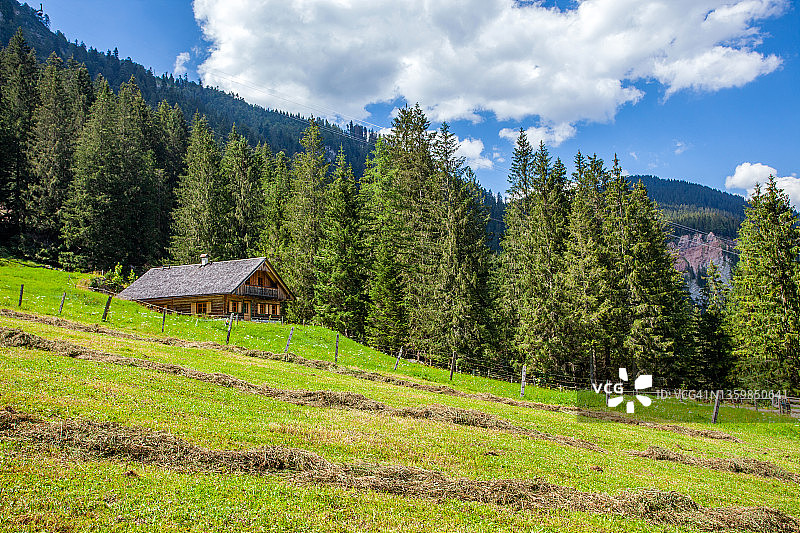奥地利阿尔卑斯山坡上的小木屋图片素材