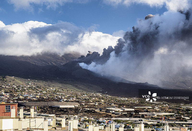 火山在城镇房屋旁喷发：拉帕尔马岛老峰火山图片素材