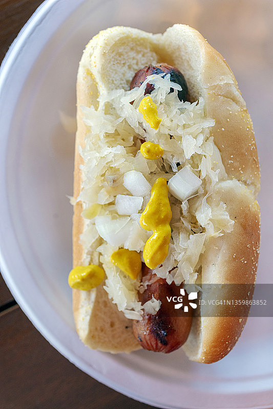 户外野餐：烤热狗配芥末、洋葱和酸菜图片素材