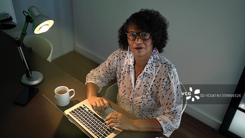 一名女性使用笔记本电脑在家里工作的肖像图片素材