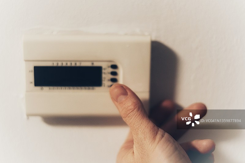 通过关闭开关和调节温度来节约能源图片素材