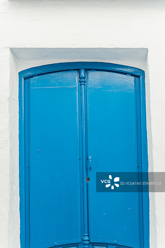 白色墙壁上的蓝色金属门图片素材