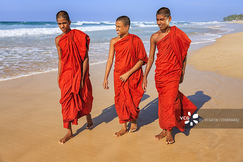斯里兰卡青年佛教僧侣在海滩上行走图片素材