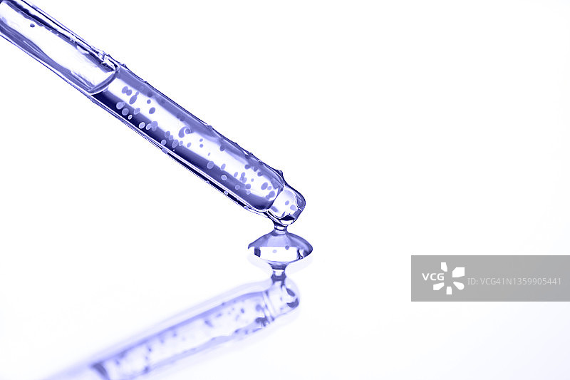 玻璃滴管倾倒紫色保湿清洁乳液，白色背景特写微距摄影，2022年度流行色图片素材