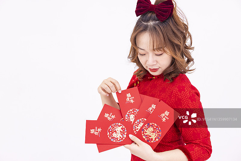 手拿红包庆祝中国新年的快乐年轻女人图片素材