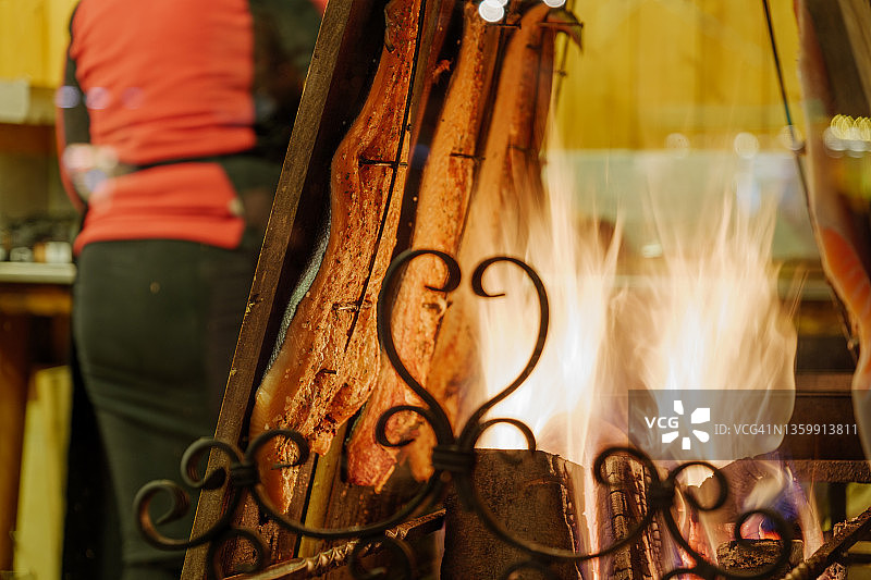 圣诞市场摊位上燃烧的篝火和悬挂的烤三文鱼图片素材