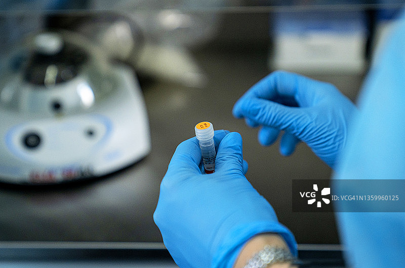 疫情概念：新型奥密克戎毒株研究、实验室研究设备和PCR、防护面罩、眼镜和防护服图片素材