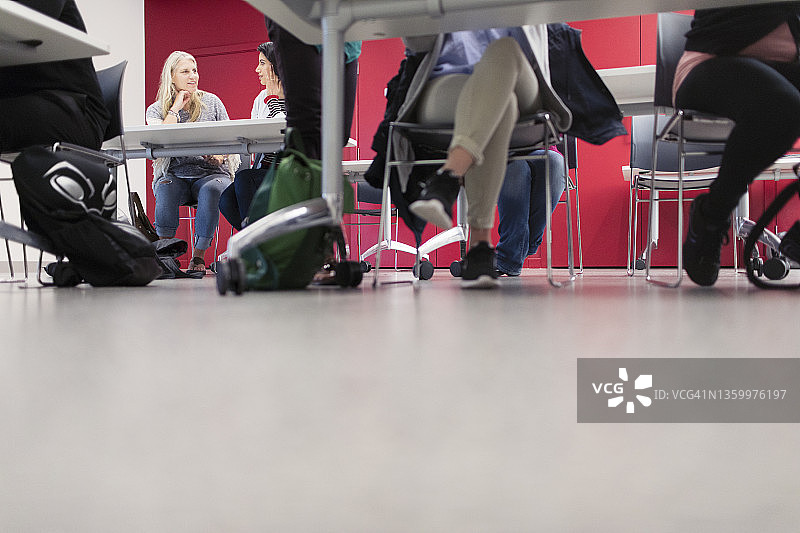 教室里课桌下社区大学学生的腿图片素材