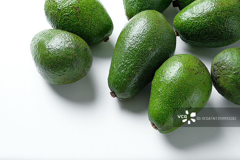 白色桌子上的绿色成熟牛油果图片素材