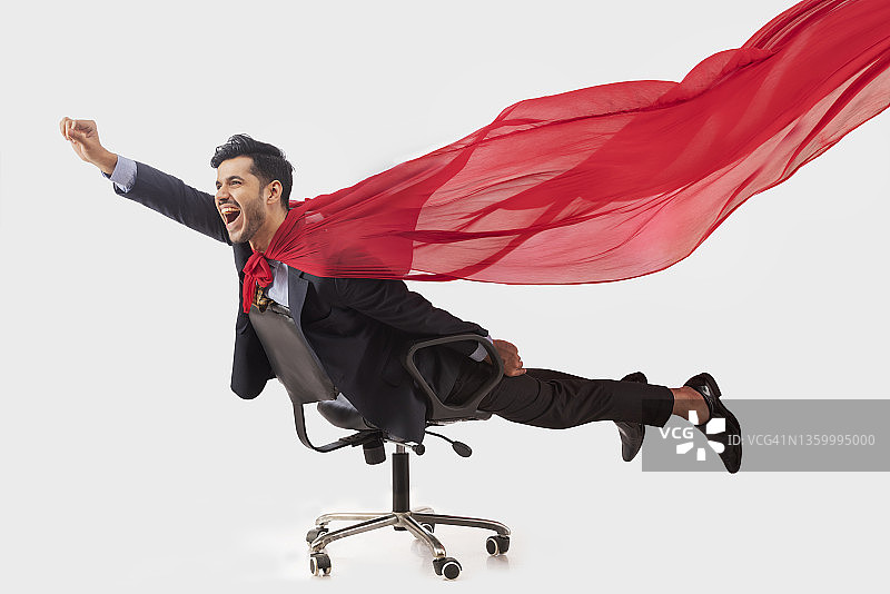 身穿正式商务套装的企业员工像超人一样躺在椅子上飞行图片素材