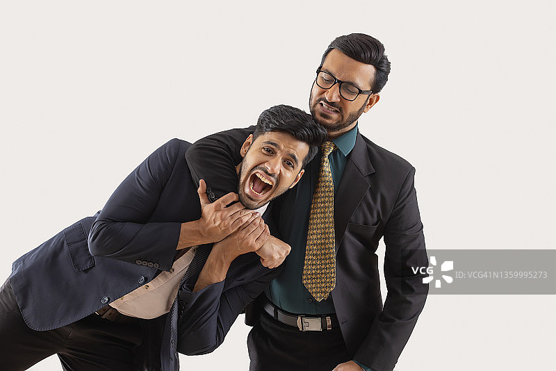 身着正装的企业员工们嬉戏打闹，一人手搭在另一人脖子上图片素材