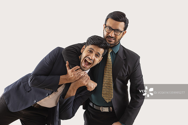 身着正装的企业员工们嬉戏打闹，一人手搭在另一人脖子上图片素材