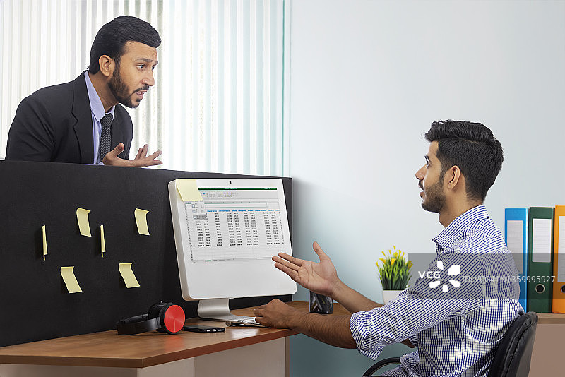 穿着正装的愤怒老板和下属公司员工在办公桌前争吵图片素材