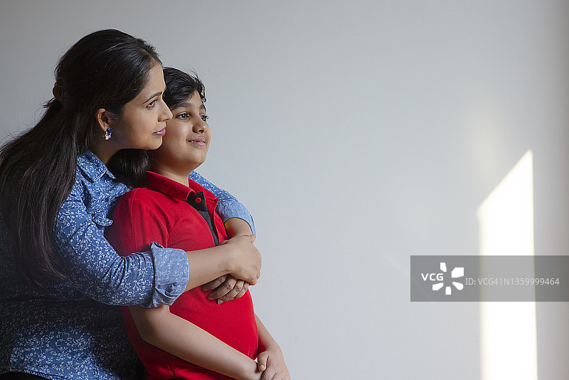 印度妇女从背后拥抱她的儿子图片素材