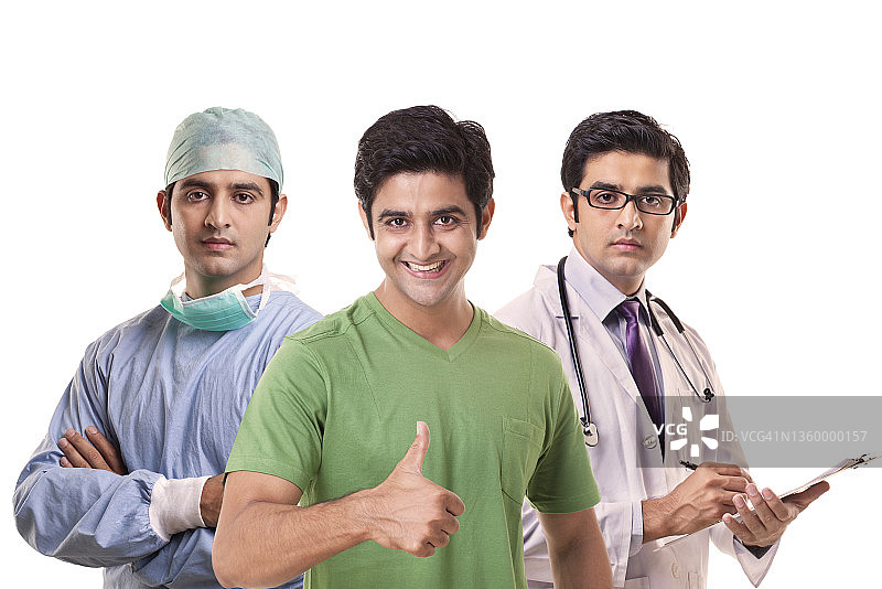 年轻男子站在两位医生之间竖起大拇指图片素材