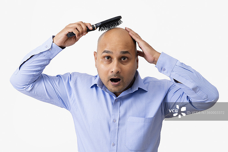 光头男人对着白色背景梳理光头肖像图片素材