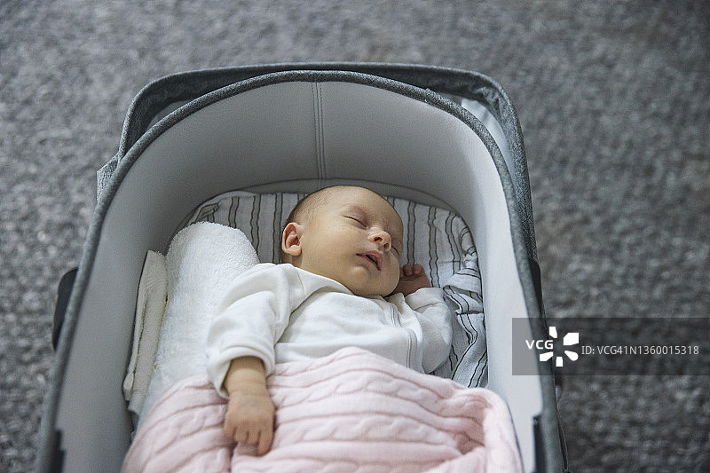 一个在童车摇篮里睡着的年轻女婴图片素材