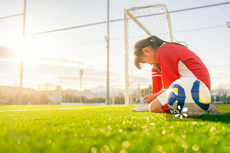 训练前系足球鞋的女小学生足球运动员图片素材