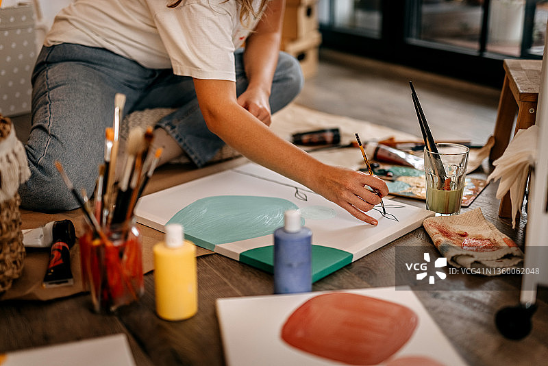 女艺术家在画布上绘画图片素材