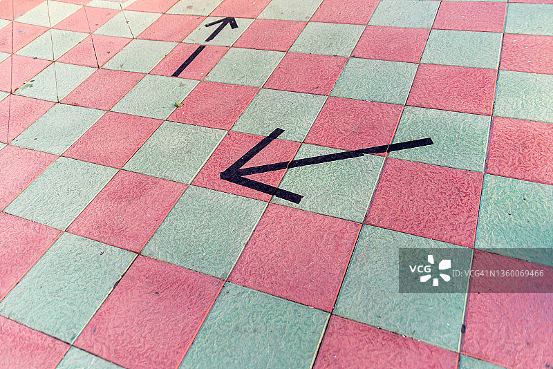 粉色和白色瓷砖地板上的黑色箭头图片素材