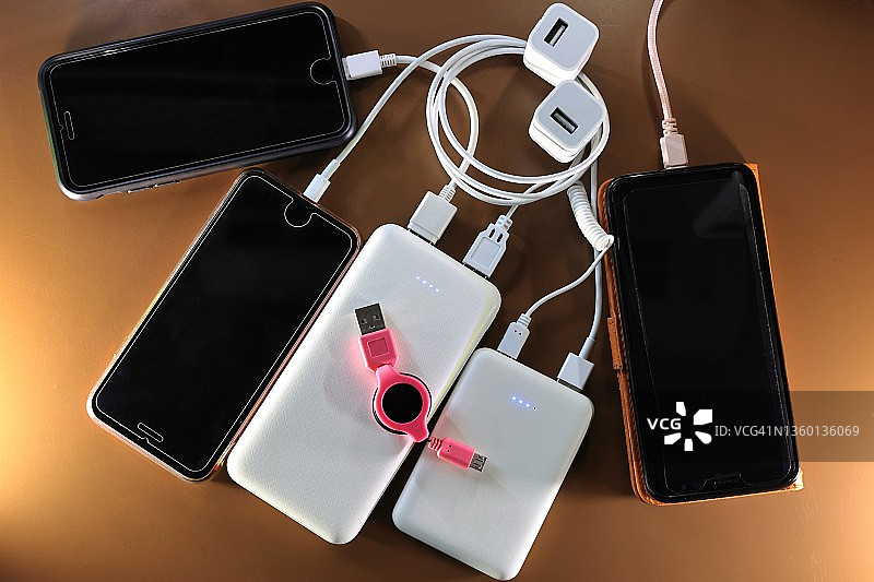 用便携式充电宝为智能手机充电图片素材