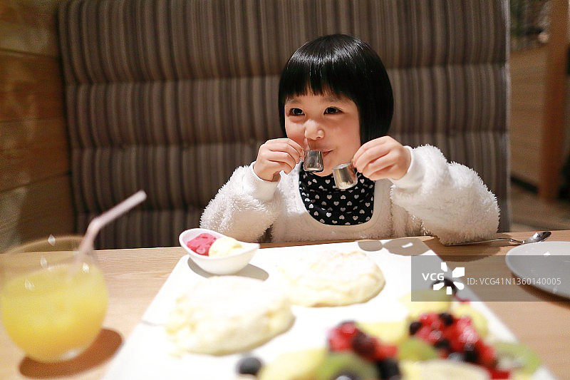 儿童饮用迷你杯中的咖啡伴侣图片素材