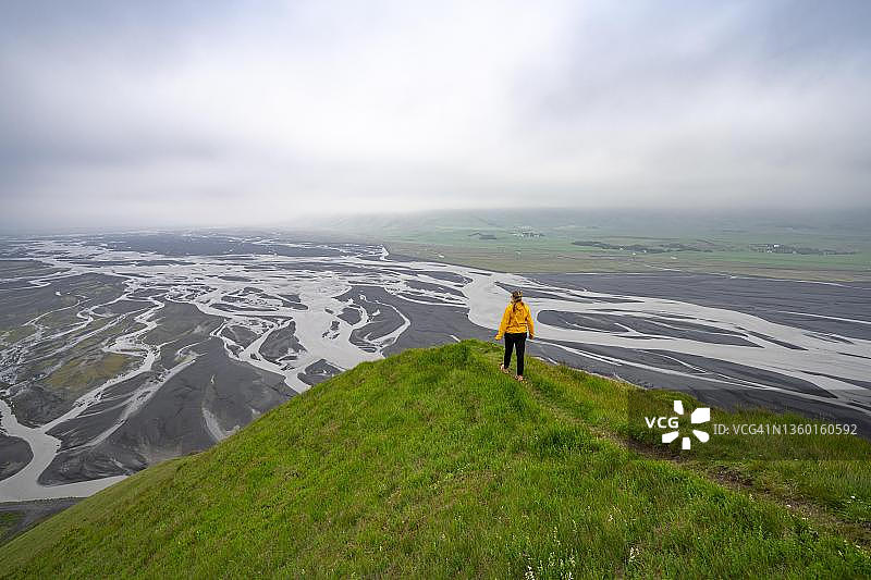 在冰岛南部地区迪莫纳雷利尔山上徒步，俯瞰冲积地和蜿蜒的河流图片素材