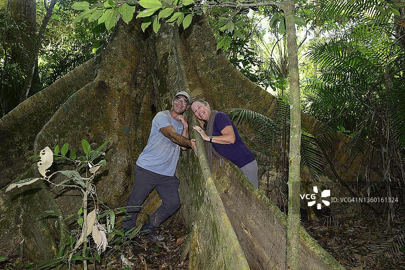 玻利维亚贝尼区鲁雷纳瓦克附近，塞雷雷生态保护区丛林巨树气根间的游客图片素材