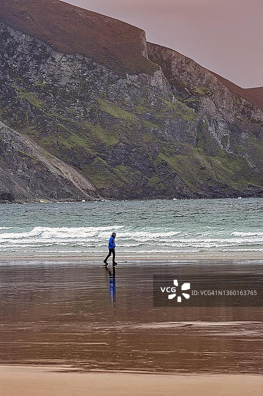 傍晚在海滩上散步的行人,基尔海滩,阿凯尔,爱尔兰梅奥郡阿基尔岛,野生大西洋之路图片素材