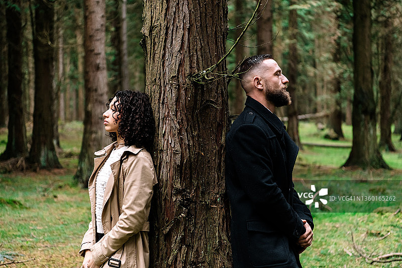 森林里，一男一女靠在树旁图片素材