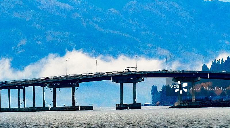 汽车行驶在加拿大不列颠哥伦比亚省奥肯那根谷基洛纳市奥肯那根湖上的桥梁上图片素材