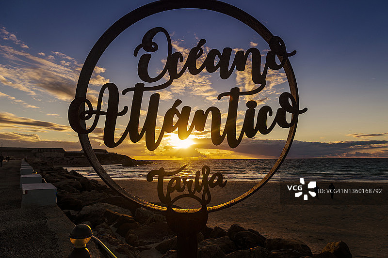 西班牙安达卢西亚加的斯塔里法海滩日落时的大西洋标志和行人轮廓图片素材