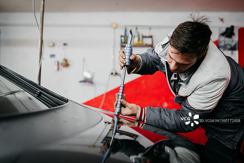 汽车修理工拆卸损坏的车辆图片素材