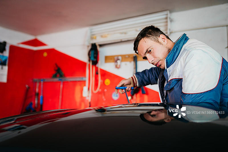 汽车修理工拆卸损坏的车辆图片素材