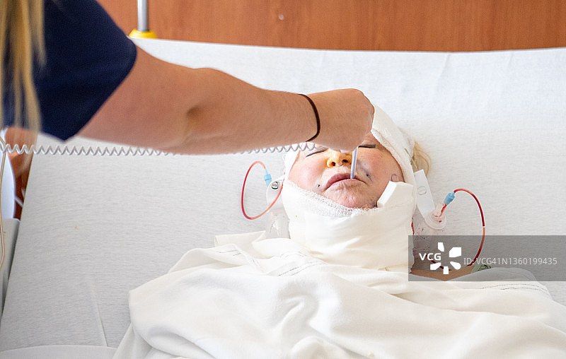 医疗系列：护士为术后老年女患者测量体温图片素材