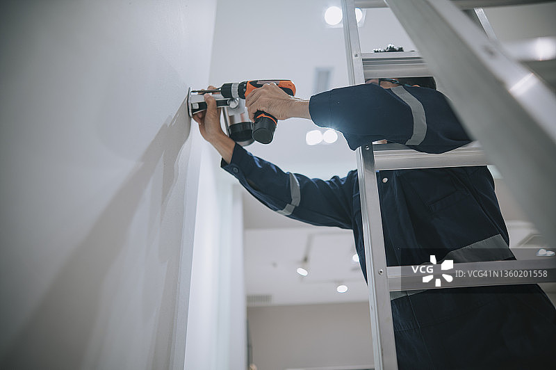 中国男子在服装店安装监控摄像头图片素材