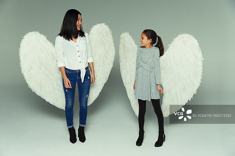 快乐的母女戴着天使翅膀图片素材