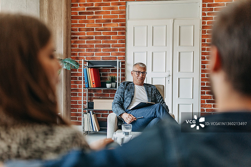 年轻情侣在咨询中与治疗师交谈图片素材