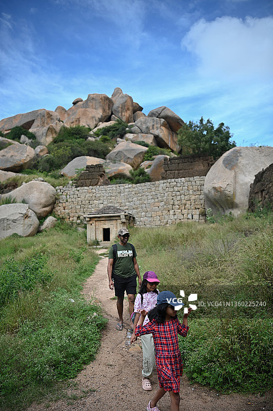父亲和女儿们走在巨石环绕的古老遗址中图片素材