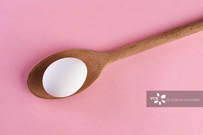 粉色背景下的鸡蛋和勺子图片素材