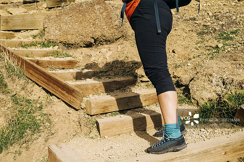 女人徒步者在泥泞小路上行走的脚部特写图片素材