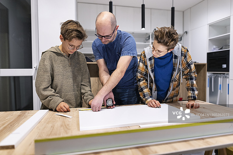 父子在家安装厨房设备图片素材