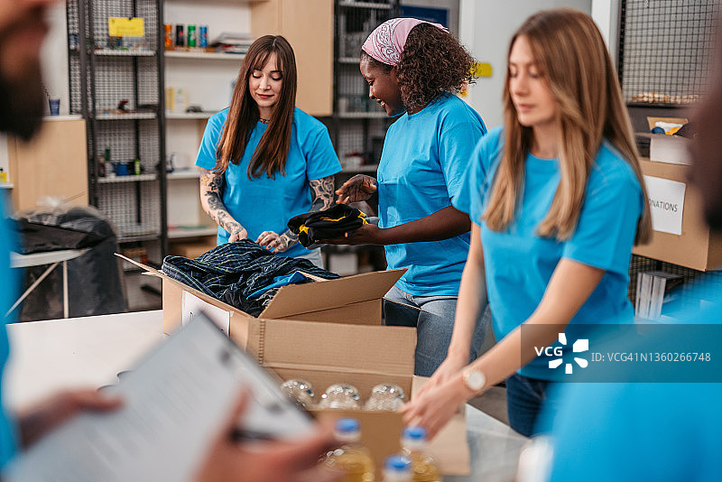 志愿者将食物和衣服装入捐赠箱图片素材
