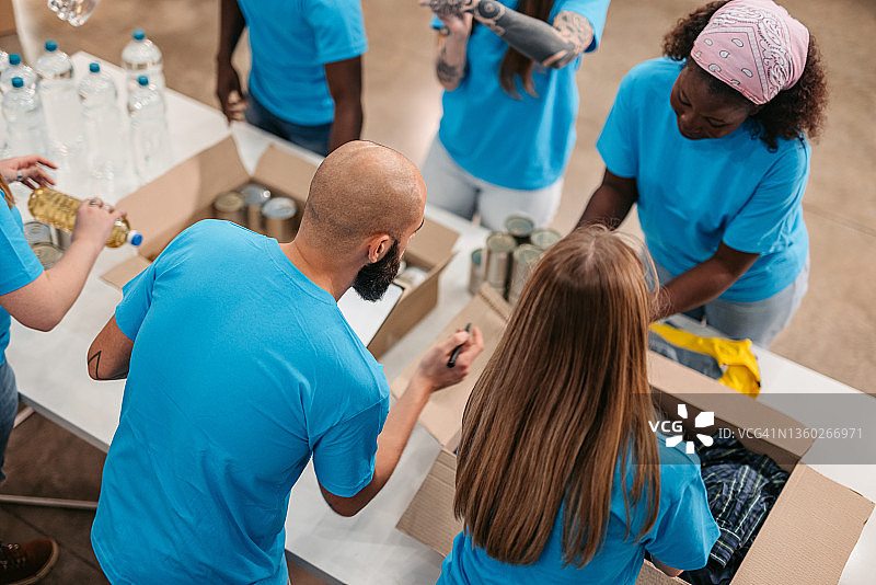 志愿者将食物和衣服装入捐赠箱图片素材
