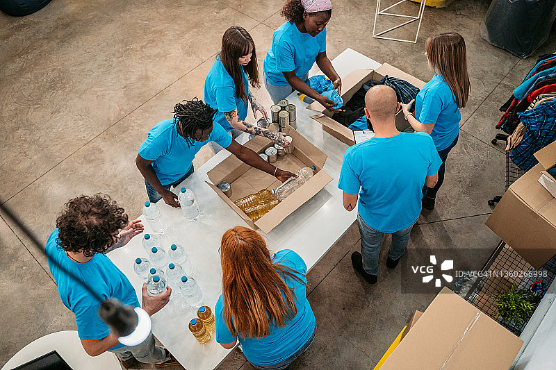 志愿者将食物和衣服装入捐赠箱图片素材
