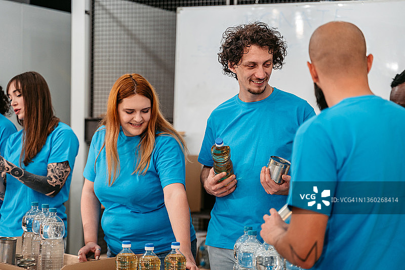 志愿者在捐赠中心整理水、油和罐头图片素材